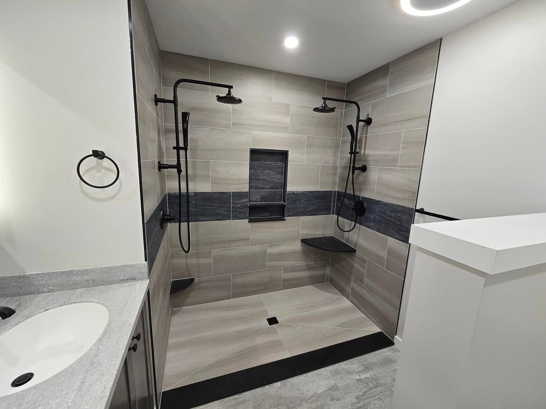 Top bathroom remodeler near you: tile walk-in shower with a dark accent band in Buckingham