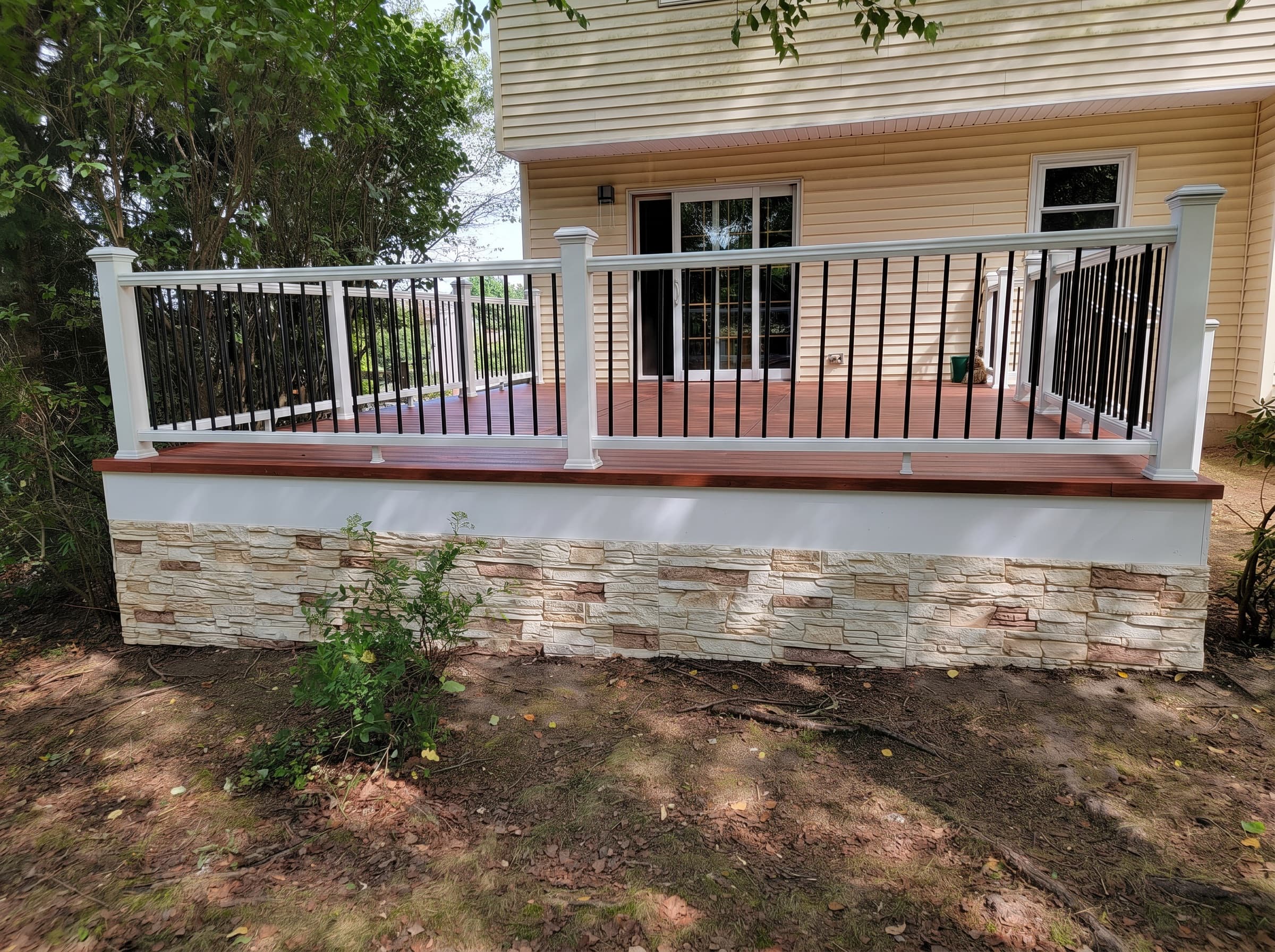 Custom deck builder near you: New Hope deck with white railings and a stone-look base