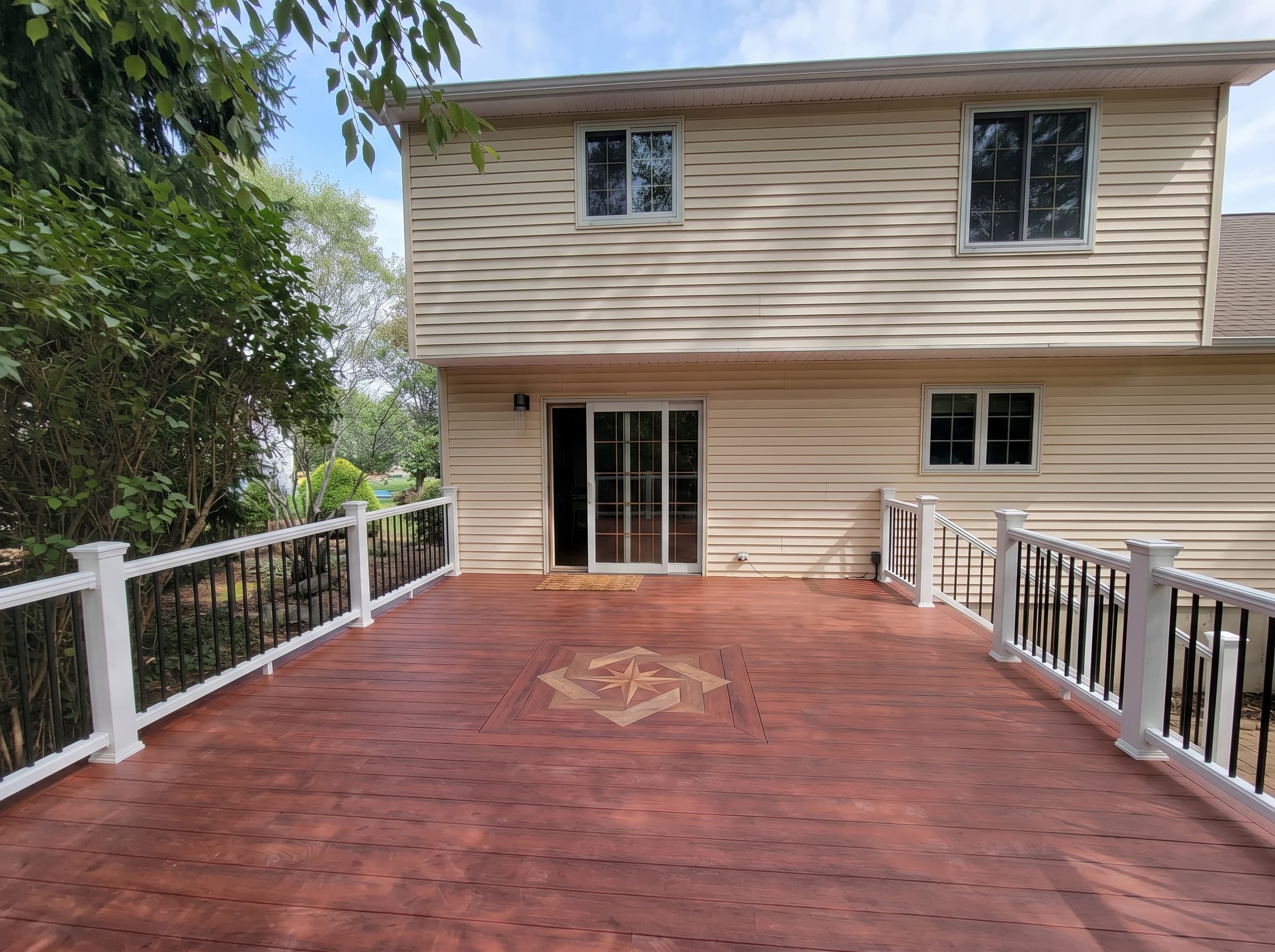 New Hope deck with white railings and a stone-look base, built by local deck builder S & B Construction and Remodeling.