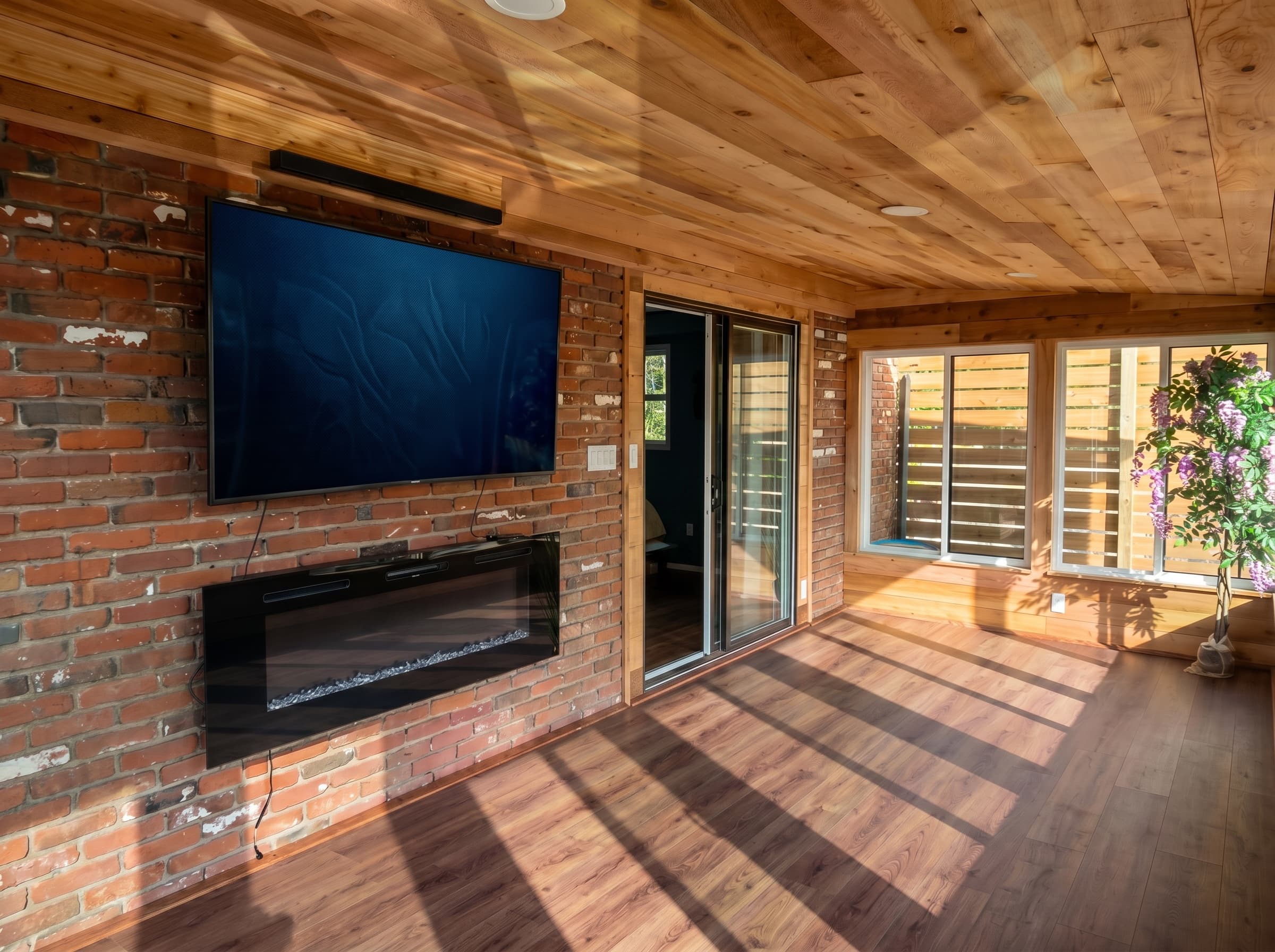Finished Telford sunroom addition with wood ceiling and brick wall